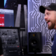 a man with beard and baseball hat looks excited about a synthesizer